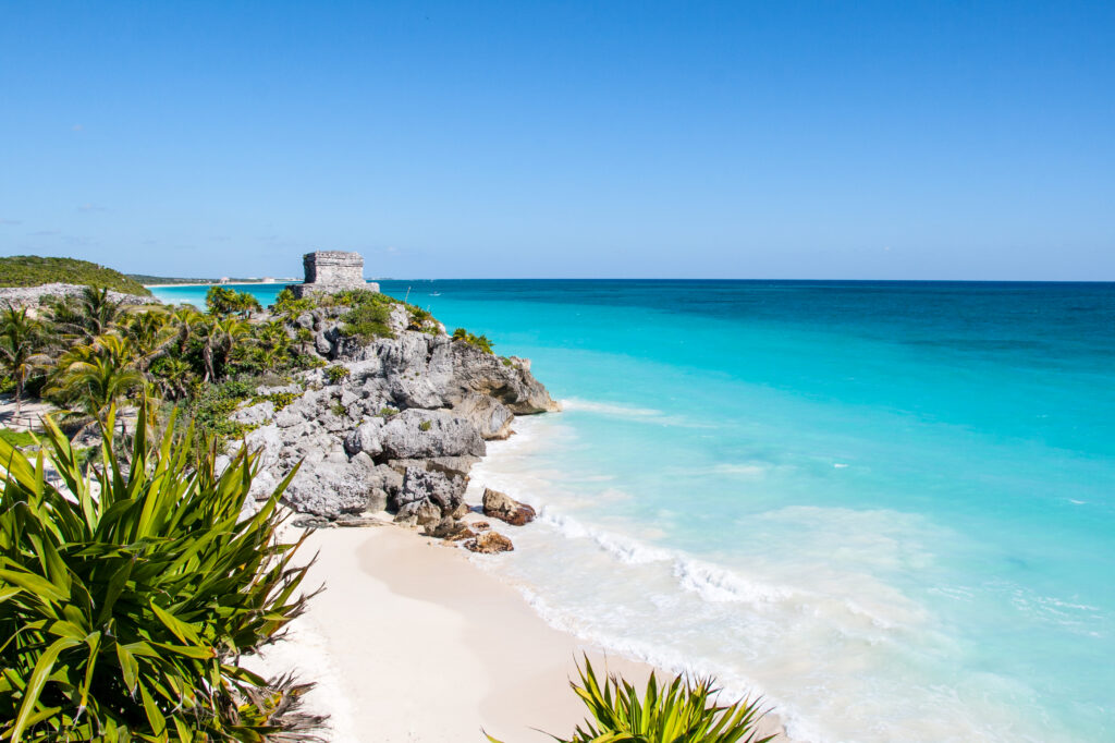 Beautiful beach with turquoise water in Tulum Mexico, Mayan ruins on top of the cliff.