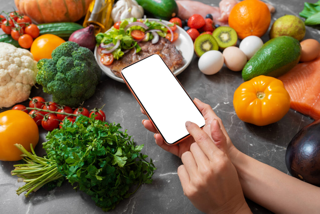 Woman using smart phone in kitchen, template for your own design