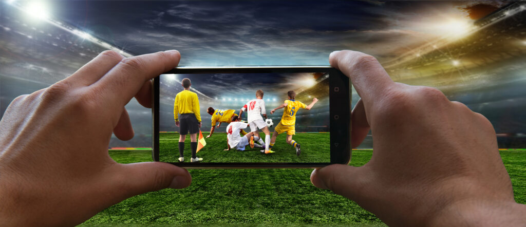 Stadium in the evening in full light before the match. Football fan removes the football game on mobile phone 2018