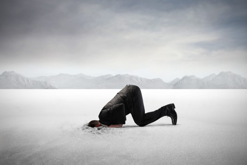 Businessman burying his head in the sand