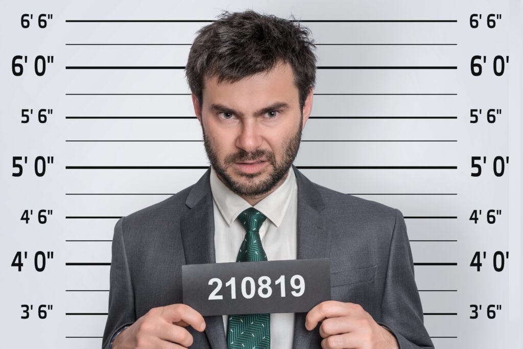 Mugshot of man in suit at police station - prisoner identification concept