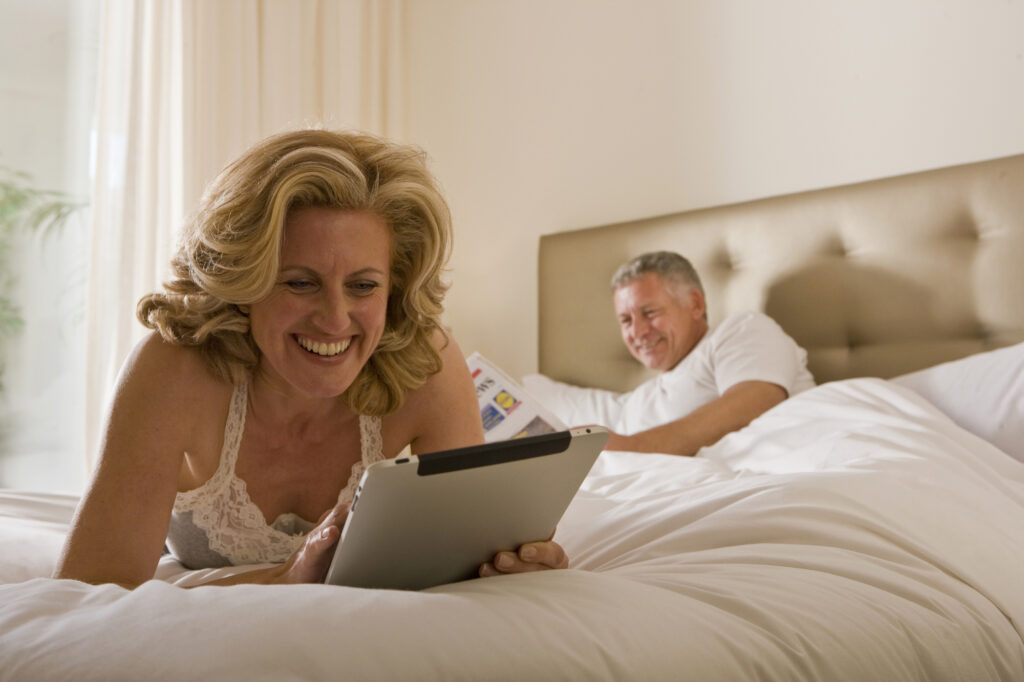 Woman using tablet computer on bed