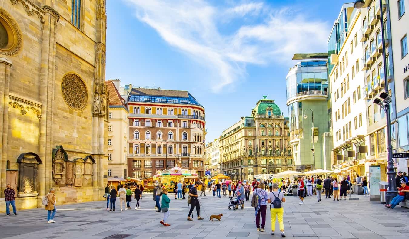 People walking around Stephansplatz Square on a sunny day in Vienna, Austria