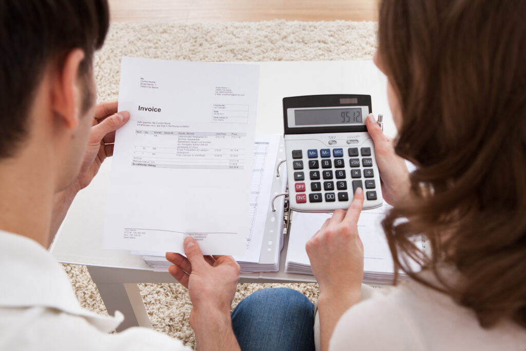 Portrait of young happy couple calculating budget