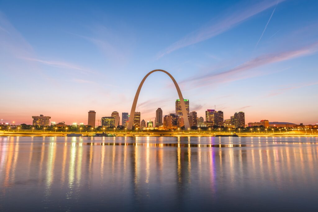 St. Louis, Missouri, USA downtown cityscape with the arch and courthouse at dusk.