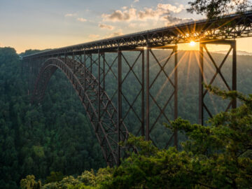 Setting sun behind the girders of the high arched New River Gorge bridge in West Virginia