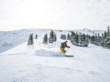 Man skiing down a snowy mountain in Vail