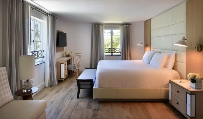 Hotel room at Hotel Ocean in Miami, with a queen sized bed and desk and decorated in warm neutral tones