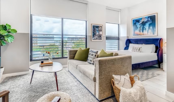 Bed and couch at an apartment with floor-to-ceiling windows at the Sentral Wynwood aparthotel in Wynwood, Miami 