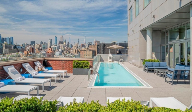 Rooftop pool with the NYC skyline in the background at Hotel Indigo in NYC