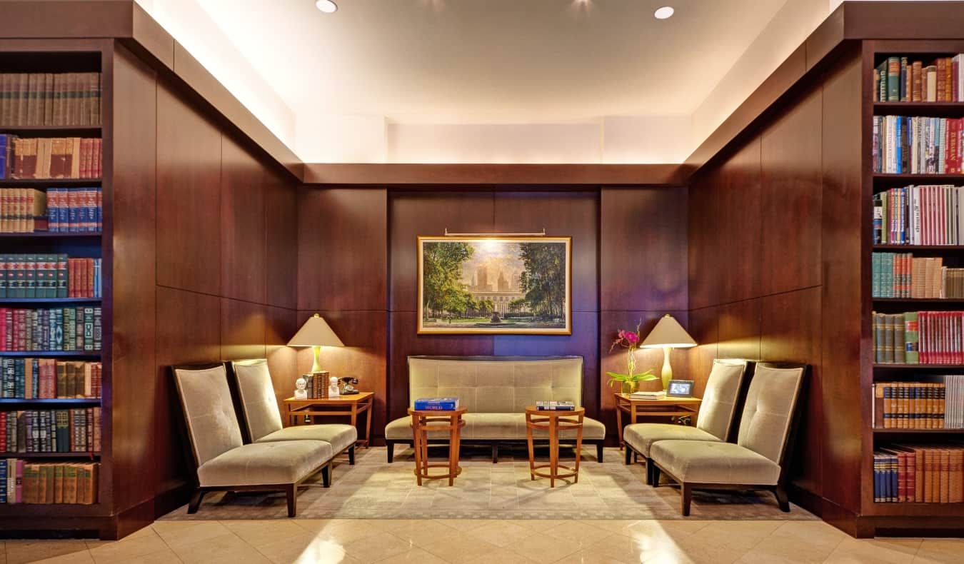 The lobby of The Library Hotel in NYC, with a seating area surrounded by floor-to-ceiling bookcases