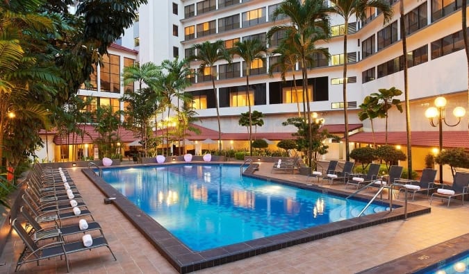 The ground floor pool at York Hotel surrounded by lounge chairs at dusk